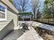 View of the outdoor patio with seating, stone tiling, and a view of the backyard and garage at 2919 Park Rd, Charlotte, NC 28209