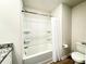 Well-lit bathroom with white shower-tub and contrasting dark wood-look vinyl floor at 3122 Maple Ridge Dr, Gastonia, NC 28052