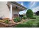 Side porch featuring a red bench, a blue birdbath and a variety of plants at 313 Garner Dr, Salisbury, NC 28146