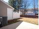 Spacious backyard featuring a concrete patio, white fence, grass, and partial views of surrounding townhomes at 3209 Blythe Ridge Ct, Charlotte, NC 28213