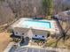 Aerial view of a community pool with blue water, surrounded by seating and trees at 3209 Blythe Ridge Ct, Charlotte, NC 28213