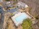 Aerial view of a community pool surrounded by lounge chairs and a fence, near condos and parking at 3209 Blythe Ridge Ct, Charlotte, NC 28213