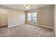 An empty bedroom with neutral walls, carpet, a ceiling fan, and natural light at 3320 Tulip Tree Ln, Charlotte, NC 28273