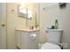 Modest bathroom with a white vanity, toilet, and a mirror above the sink and countertop at 3345 Hunting Wood Ct, Gastonia, NC 28052