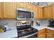 Modern kitchen with stainless steel appliances, range hood, and white countertops at 3345 Hunting Wood Ct, Gastonia, NC 28052