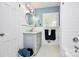 Stylish bathroom with white tile, modern vanity, round mirror, and decorative accents at 3615 Henshaw Rd, Charlotte, NC 28209