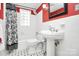 Classic bathroom with pedestal sink, black-and-white tile, and vintage-inspired decor at 3615 Henshaw Rd, Charlotte, NC 28209