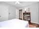 Serene bedroom with white walls, book shelf, neutral tones, and hardwood floors at 3615 Henshaw Rd, Charlotte, NC 28209