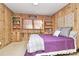 Wood-paneled bedroom with a comfortable bed, shelving, and ambient lighting at 3615 Henshaw Rd, Charlotte, NC 28209