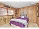 Wood-paneled bedroom with a comfortable bed, shelving, and ambient lighting at 3615 Henshaw Rd, Charlotte, NC 28209