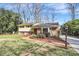 Inviting two-story home with yellow siding and brick accents, complemented by mature landscaping and a walkway at 3615 Henshaw Rd, Charlotte, NC 28209