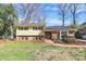 Charming two-story home with a combination of yellow siding, brick accents, and a well-maintained lawn at 3615 Henshaw Rd, Charlotte, NC 28209