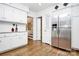 Spacious kitchen with stainless steel refrigerator, white cabinets, and hardwood floors at 3615 Henshaw Rd, Charlotte, NC 28209