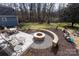 An inviting outdoor space boasting a stone fire pit, patio seating, and mature trees at 4000 Bridgewood Ln, Charlotte, NC 28226