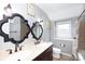 Bathroom features double sink vanity, wall lighting and tiled shower at 4000 Bridgewood Ln, Charlotte, NC 28226