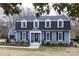 Charming two-story home featuring blue siding, black shutters, and manicured landscaping at 4000 Bridgewood Ln, Charlotte, NC 28226