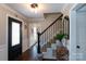 Elegant foyer with dark hardwood floors, staircase with iron railing, and a horseshoe decoration at 4000 Bridgewood Ln, Charlotte, NC 28226