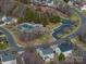 Aerial view showcases community pool, playground, surrounding houses, and winding neighborhood roads at 4075 Creekstone Trce, Gastonia, NC 28056