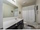 Well-lit bathroom with a modern vanity, a large mirror, and a shower-tub combination at 4075 Creekstone Trce, Gastonia, NC 28056