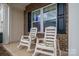 Inviting front porch featuring comfortable chairs and views of brick accents, decorative shutters, and a manicured lawn at 4075 Creekstone Trce, Gastonia, NC 28056