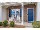 Inviting front porch with decorative chairs, neat landscaping, brick accents, and a vibrant blue front door at 4075 Creekstone Trce, Gastonia, NC 28056