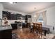 Open-concept kitchen with dark cabinetry, stainless steel appliances, and an adjacent dining area with lots of natural light at 4075 Creekstone Trce, Gastonia, NC 28056