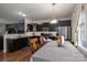 Open-concept kitchen with dark cabinetry, stainless steel appliances, an adjacent dining area, and views into the living room at 4075 Creekstone Trce, Gastonia, NC 28056