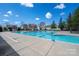 Community pool showcasing bright blue water, surrounding concrete, and community homes in the background at 4075 Creekstone Trce, Gastonia, NC 28056