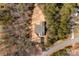 An aerial view shows the house's layout, its roof, deck, and surroundings with trees on a sunny day at 433 Cornerstone Dr, Taylorsville, NC 28681