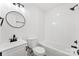 Well-lit bathroom showcases a modern vanity, circular mirror, and a shower-tub combo with white tile at 433 Cornerstone Dr, Taylorsville, NC 28681