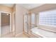 Bright bathroom with a soaking tub, glass-enclosed shower, and a glass block window at 485 Sutro Forest Nw Dr, Concord, NC 28027