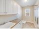 Efficient laundry room with ample storage, white cabinets, and a convenient utility sink at 485 Sutro Forest Nw Dr, Concord, NC 28027