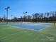 Community tennis courts surrounded by a black fence and mature trees at 485 Sutro Forest Nw Dr, Concord, NC 28027