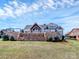 Beautiful backyard with stone retaining wall and covered patio overlooking a lush lawn at 5086 Windward Point Ln, Denver, NC 28037