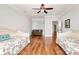 Bright bedroom with hardwood floors, ceiling fan, comfortable sofa, and two beds at 5086 Windward Point Ln, Denver, NC 28037