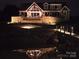 Night exterior view of waterfront home showcasing its stonework and architectural lighting at 5086 Windward Point Ln, Denver, NC 28037