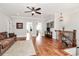 Inviting living room with hardwood floors, ceiling fan, comfortable sofa, and staircase at 5086 Windward Point Ln, Denver, NC 28037