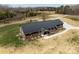 Aerial view of a brick home featuring a modern metal roof and a circular driveway at 515 Panhandle Rd, Gold Hill, NC 28071