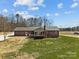 Rear view of brick home featuring a back door, small deck area and nicely maintained yard at 515 Panhandle Rd, Gold Hill, NC 28071