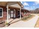 A welcoming brick home featuring a charming front porch with decorative columns and flower pots at 515 Panhandle Rd, Gold Hill, NC 28071