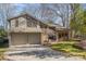 Two-story home featuring a two car garage, brick facade, dormer windows, a manicured lawn, and mature trees at 5213 Wood Lake Dr, Belmont, NC 28012