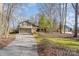 Home featuring a two-car garage, well-manicured lawn, and mature trees at 5213 Wood Lake Dr, Belmont, NC 28012