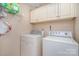 Functional laundry room with washer, dryer, and overhead cabinets at 5213 Wood Lake Dr, Belmont, NC 28012