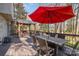 Outdoor dining area with a table, seating, red umbrella, and view of the backyard at 5213 Wood Lake Dr, Belmont, NC 28012