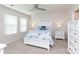 Bright main bedroom featuring a ceiling fan, white furniture, and two windows at 5341 Orchid Bloom Dr # 55, Fort Mill, SC 29707