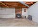 Basement featuring a brick fireplace with a wood-burning stove, concrete floor and exposed ceiling at 5830 W Nc 10 Hwy, Hickory, NC 28602