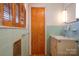 Bathroom sink, vintage wooden blinds, light blue tile walls, and wood door at 5830 W Nc 10 Hwy, Hickory, NC 28602