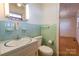 Bathroom sink and mirror, light blue tile walls, and a toilet at 5830 W Nc 10 Hwy, Hickory, NC 28602