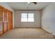 Empty bedroom with beige carpet, a window, a ceiling fan, and a closet at 5830 W Nc 10 Hwy, Hickory, NC 28602