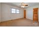 A carpeted bedroom with wood doors, neutral walls, and a ceiling fan at 5830 W Nc 10 Hwy, Hickory, NC 28602